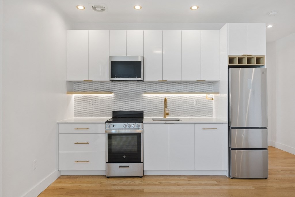 a kitchen with white cabinets and stainless steel appliances